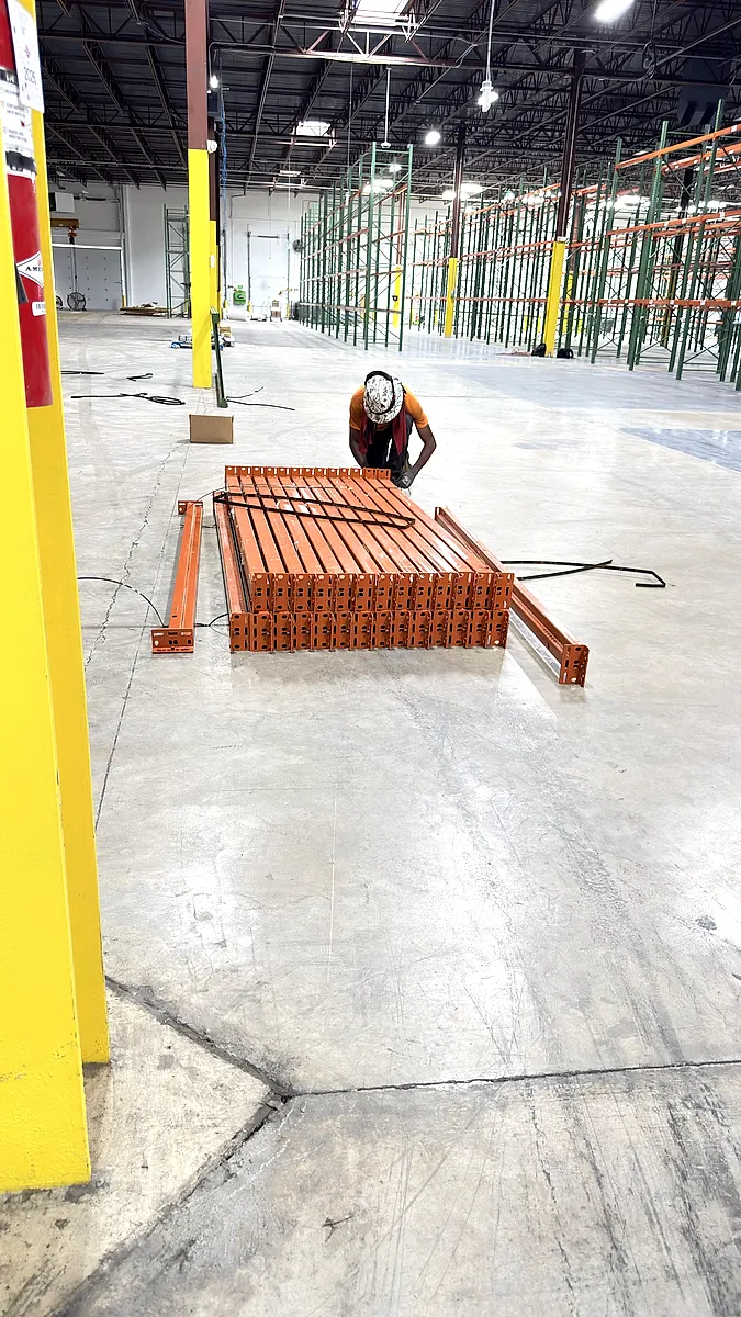 Bundle of pallet rack beams staged on the warehouse floor