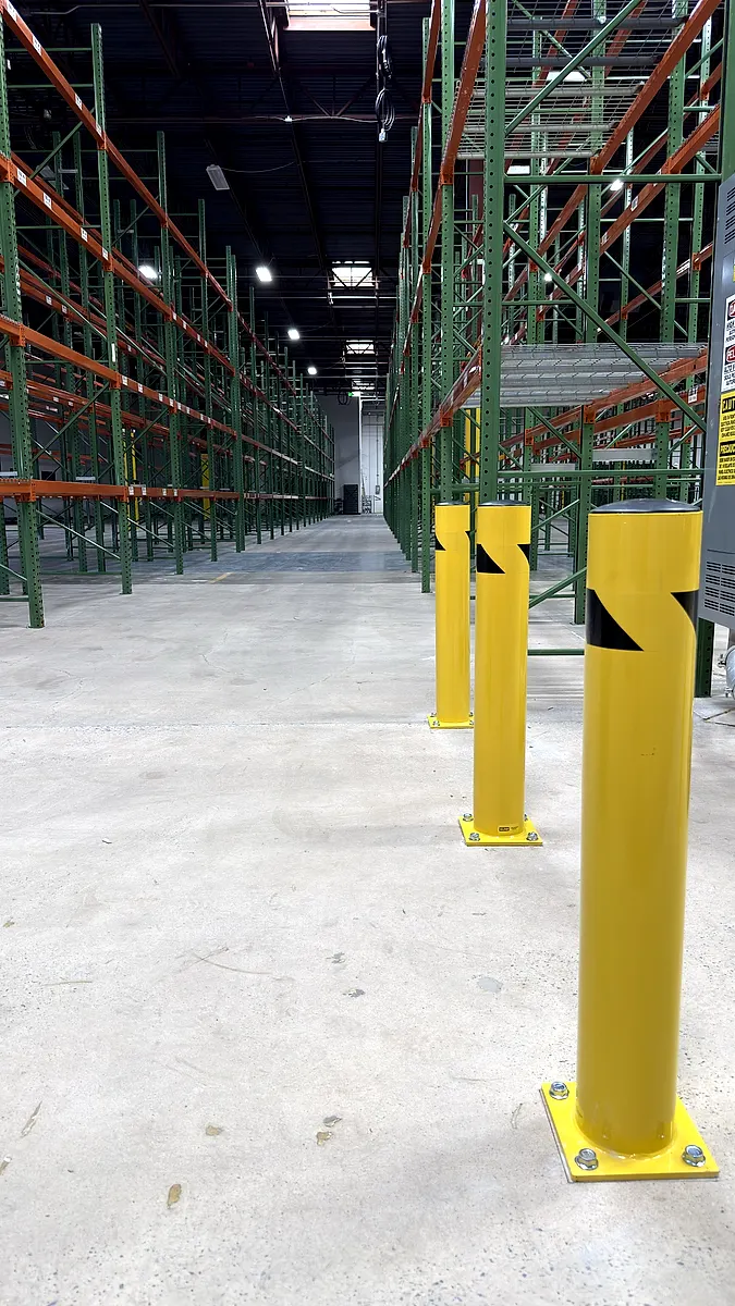 Yellow steel bollards protecting a rack aisle